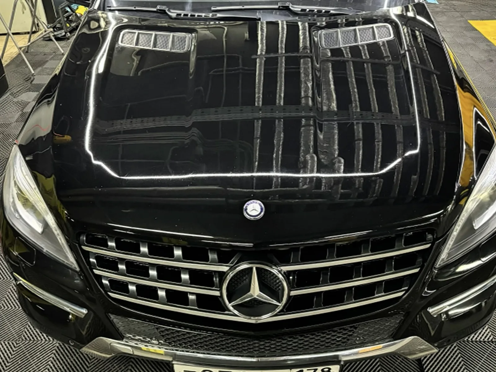 Капот и решётка Mercedes-Benz ML 350 после полировки: зеркальные отражения ламп бокса